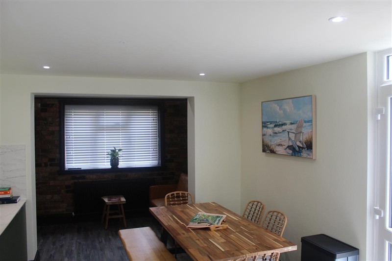 Dining area beside a media wall